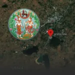 Satellite map with a red location pin near a lake, overlaid by a circular Thai artwork depicting two mythic figures among greenery.