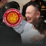 Smiling man in a white shirt hugs someone in a group greeting, with a red Department of Corrections emblem overlaying the scene.
