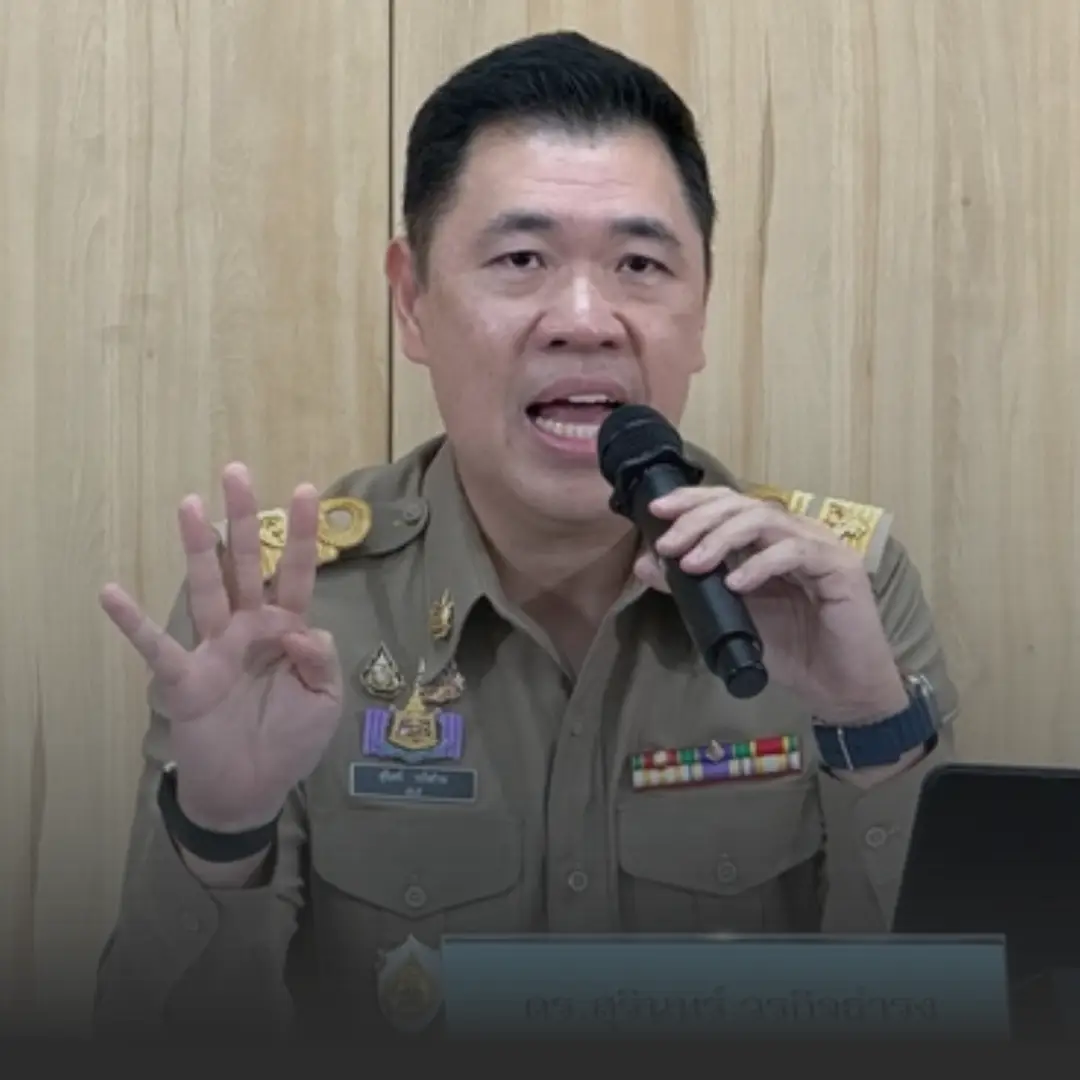 คพโต้ผลสำรวจ กกร หลังถูกระบุเรียกรับสินบนสูงสุด » The Mainstream Male official in a tan uniform speaks into a handheld microphone, gesturing with four fingers raised in front of a wood-paneled backdrop with medals on his chest.