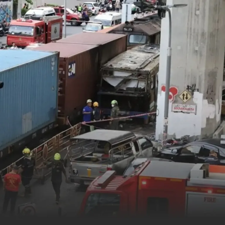 Truck and container crash scene with responders and damaged vehicles in a city street.