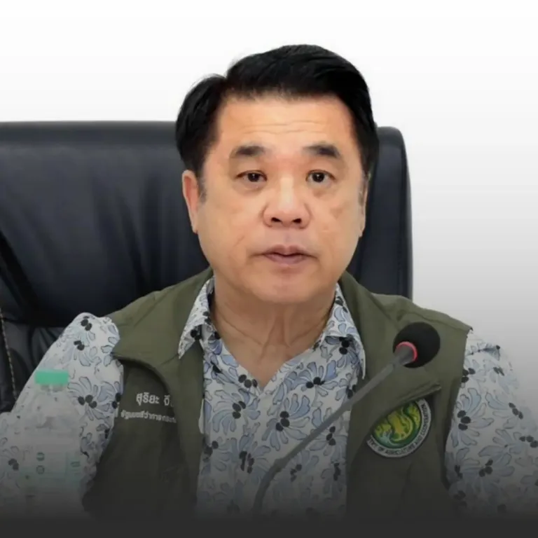 Middle-aged man in a floral shirt and green vest speaks into a microphone at a press briefing.