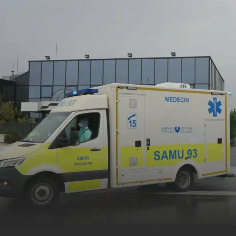 French emergency ambulance SAMU 93 with Médecin markings parked outside a glass-front building.